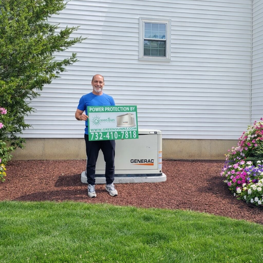 Allentown, NJ homeowner holding a Green Sun Energy Services sign next to a Generac standby generator installed and maintained by Green Sun Energy Services, LLC